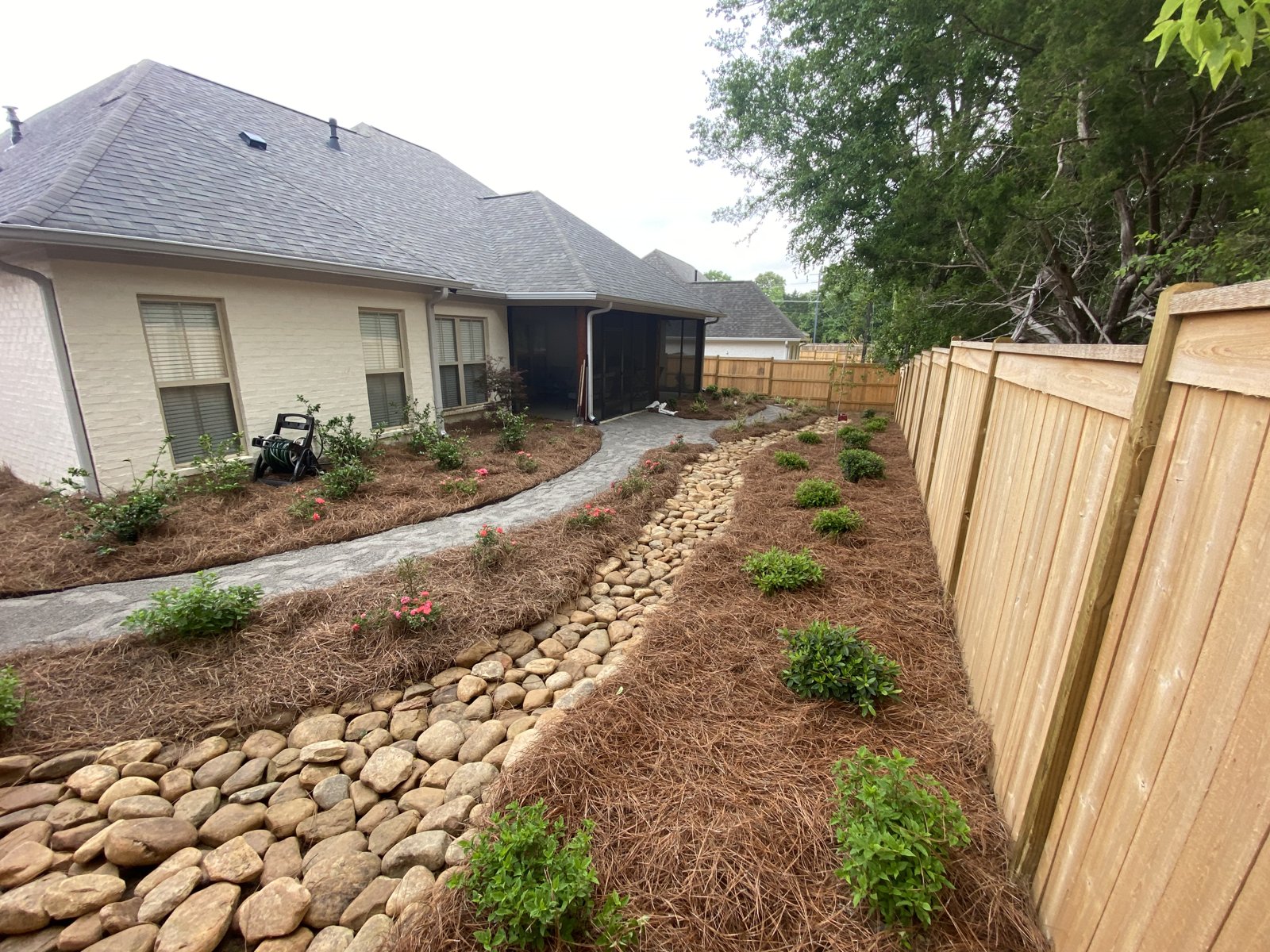 Finished dry creek, curved walkway, and planting beds