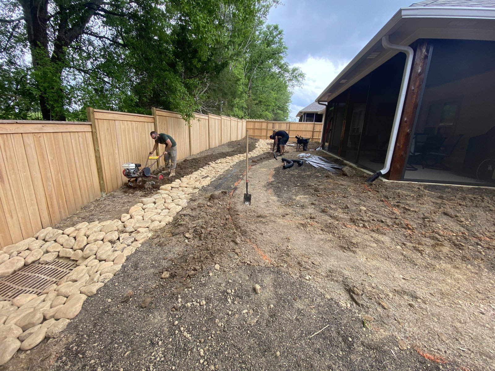 Progress: river-rock drainage swale